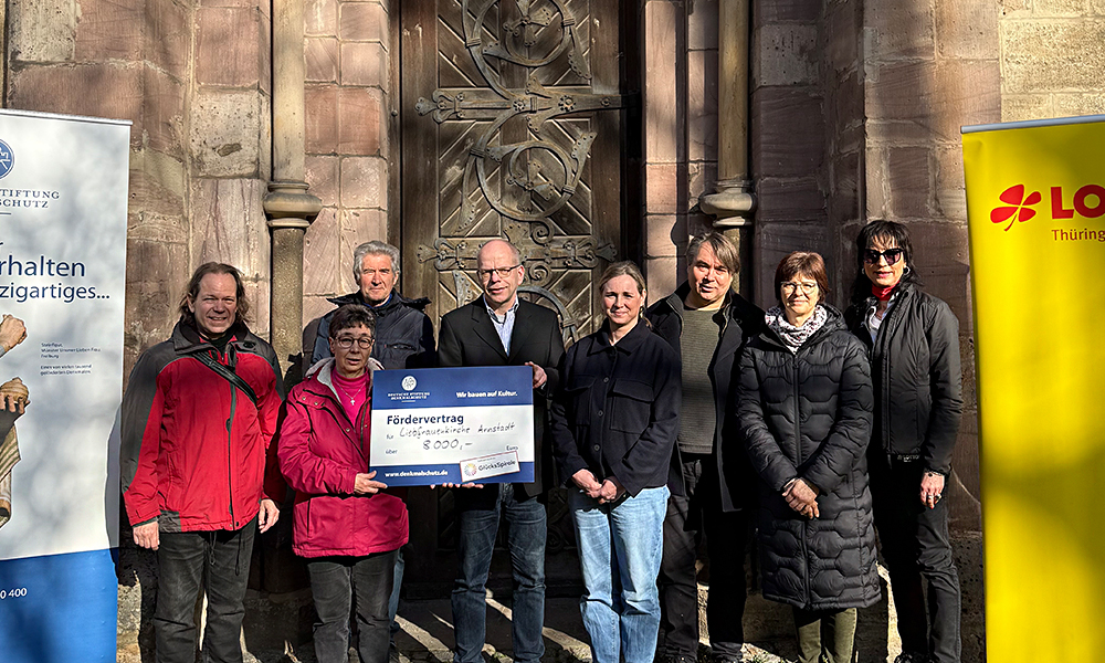 Übergabe des symbolischen Fördermittelschecks vor dem Gebäude der Liebfrauenkirche in Arnstadt